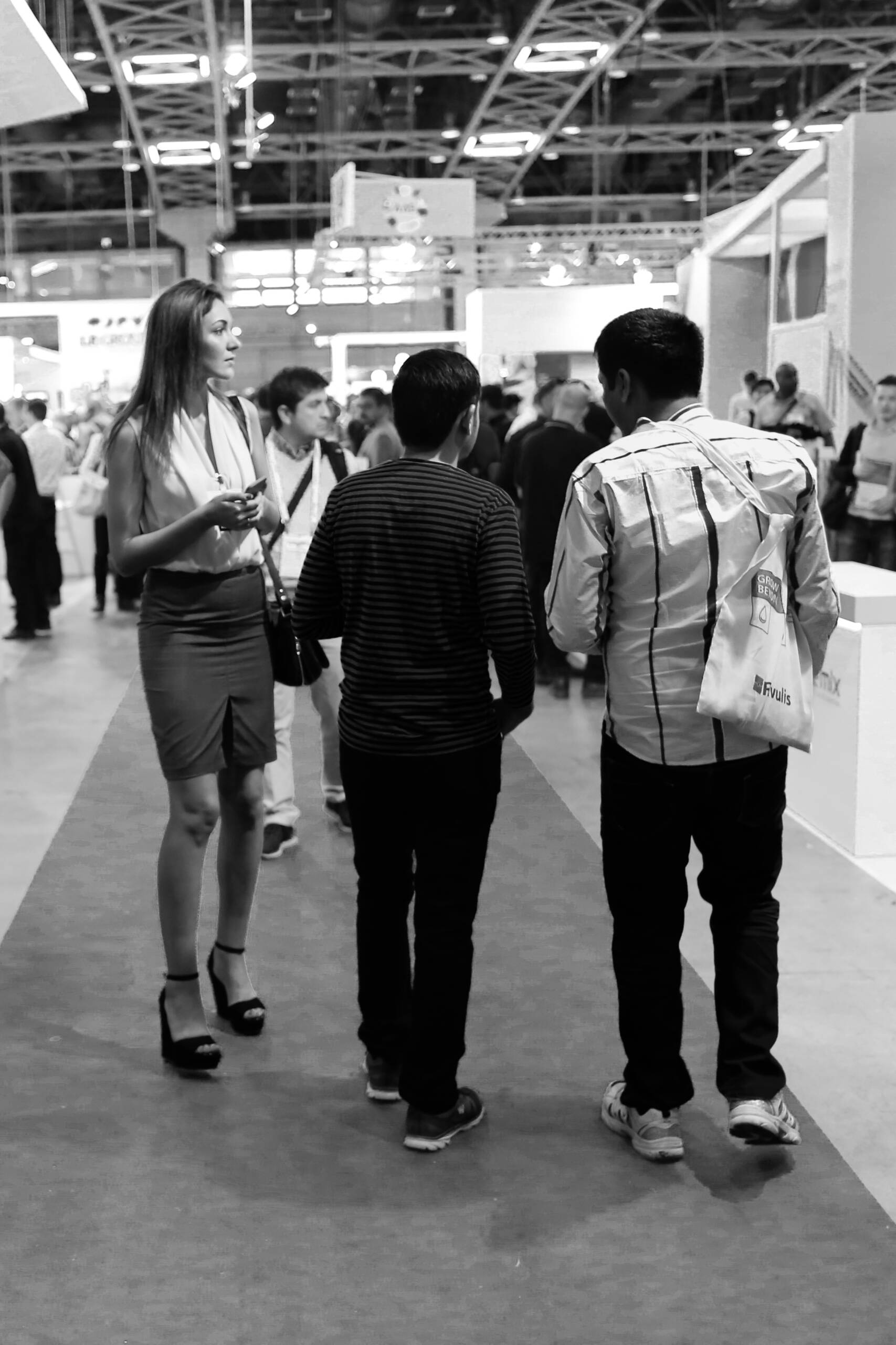 Attendees walking the main aisle of a trade show floor