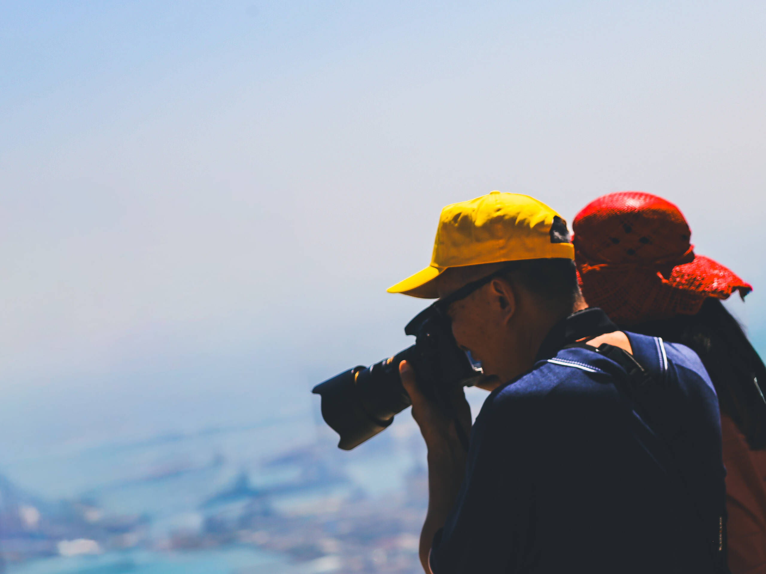 Photographer shooting from a high vantage point over a hazy coastal city